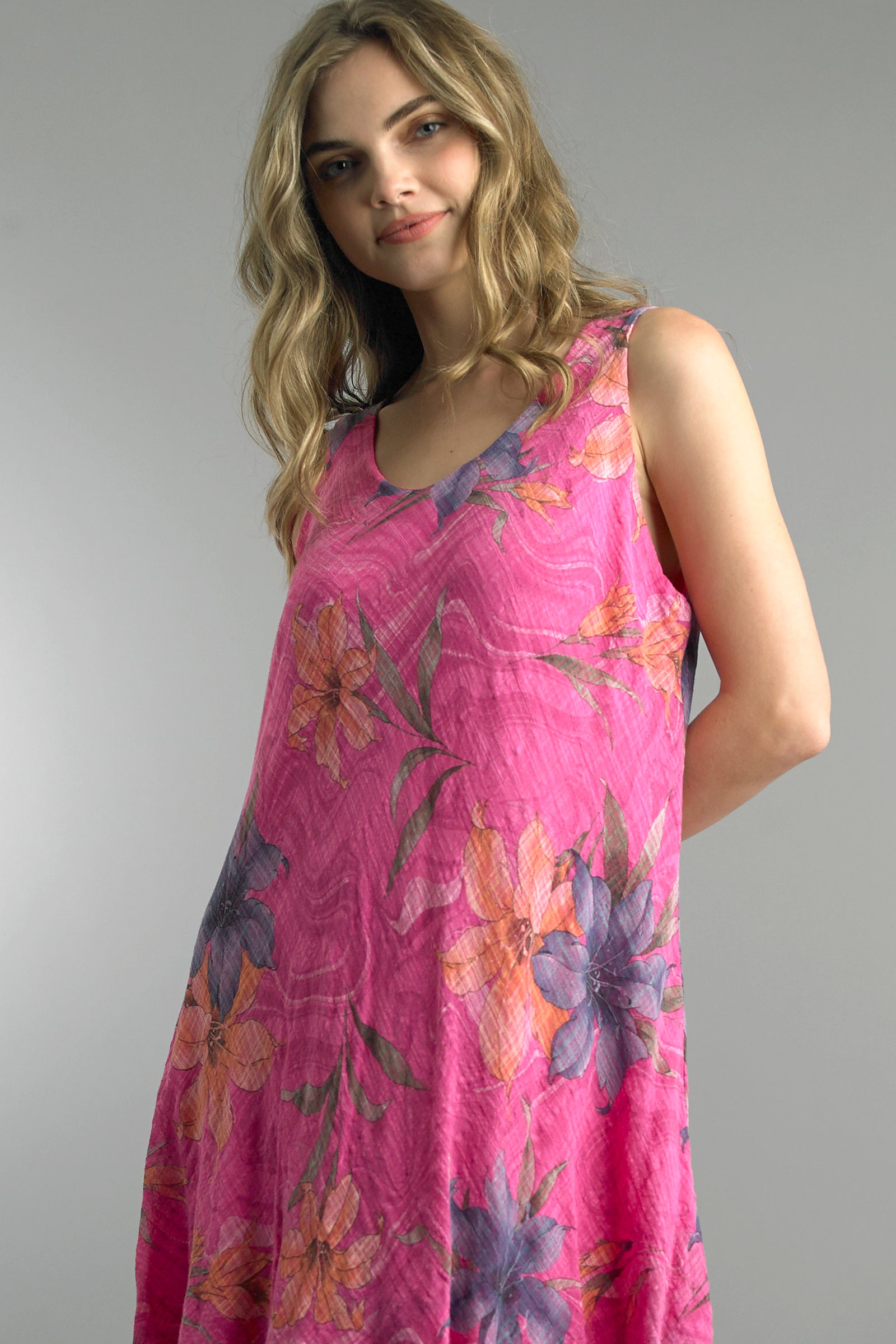 Woman wearing a pink floral dress against a gray background
